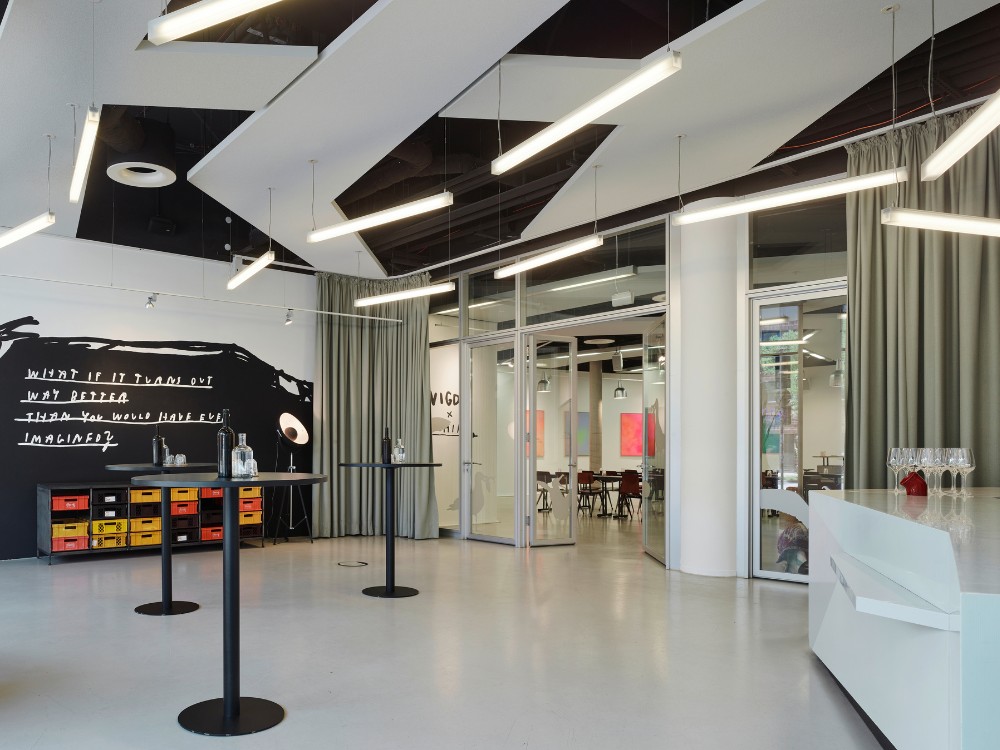 Modern event space with minimalist decor, featuring black and white art, sleek furniture, and soft lighting. 