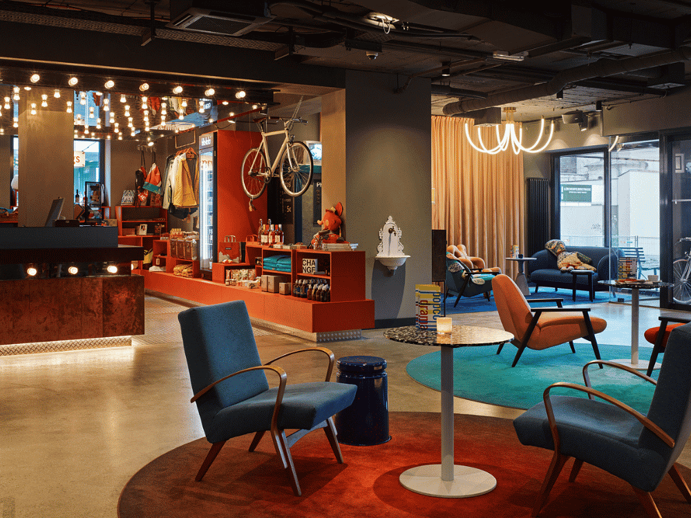 A hotel lobby featuring a bicycle prominently displayed in the center, surrounded by seating and decorative elements.