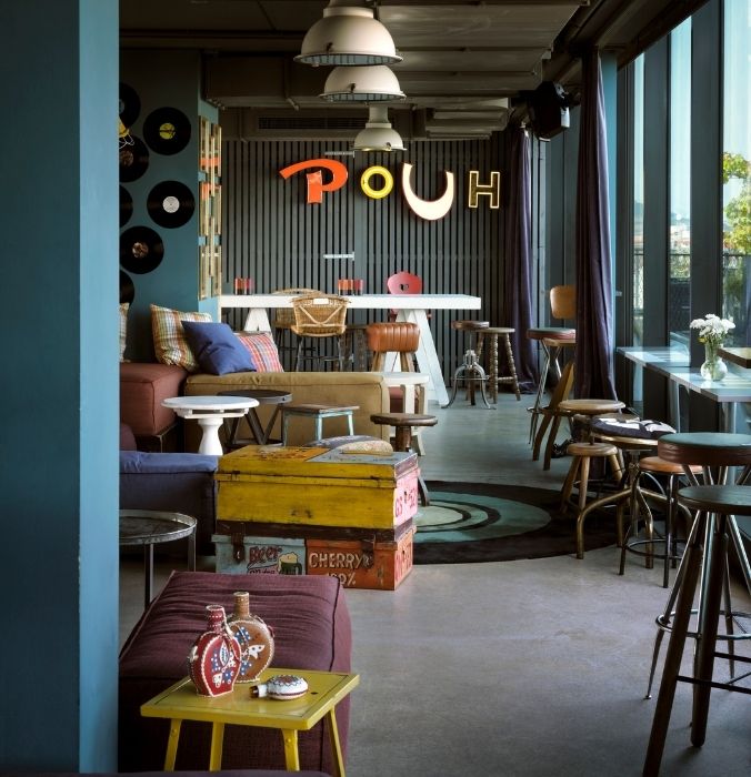 A vibrant bar interior featuring colorful furniture and lively decor, creating a cheerful atmosphere.