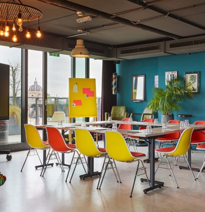 A spacious room filled with rows of chairs and tables arranged for a gathering or meeting.