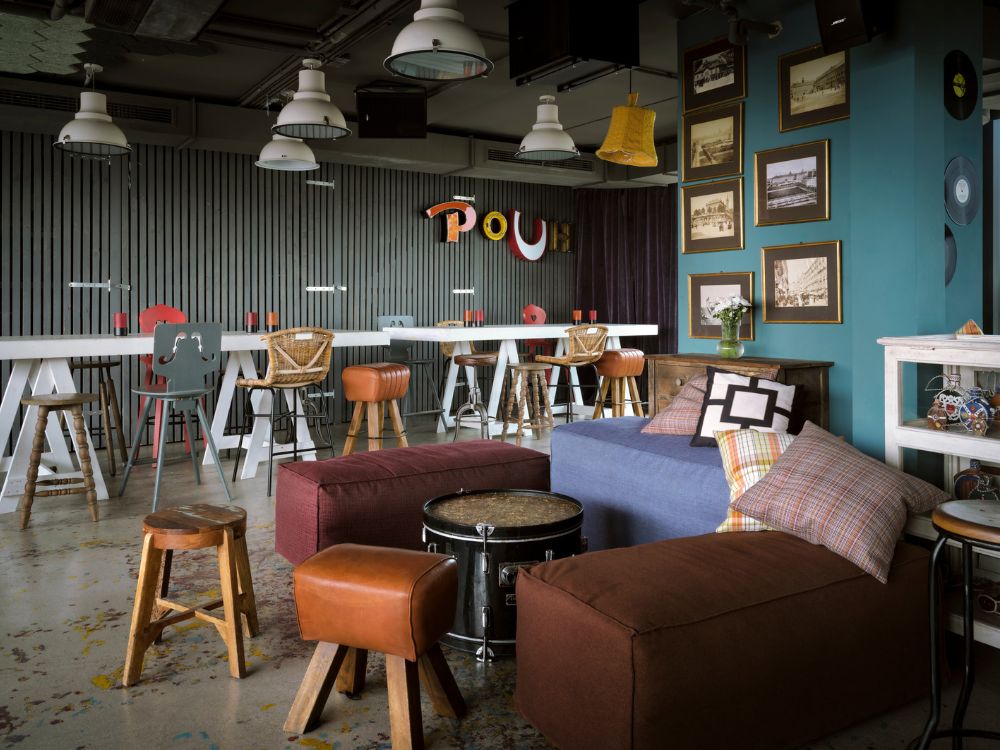 A bright and colorful room showcasing a bar area surrounded by stylish chairs, enhancing the lively ambiance.
