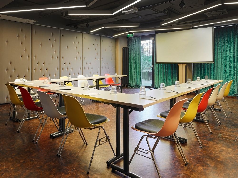 A conference room featuring several chairs arranged around a projector screen for presentations.