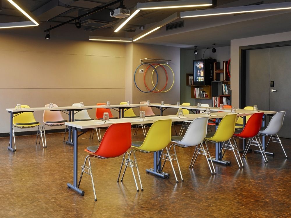 A conference room featuring several chairs arranged around tables, suitable for meetings and discussions.