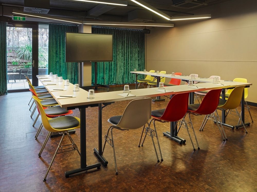 A conference room featuring several chairs arranged around tables, suitable for meetings and discussions.