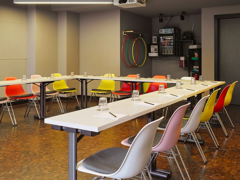 A conference room featuring several chairs arranged around tables, suitable for meetings and discussions.