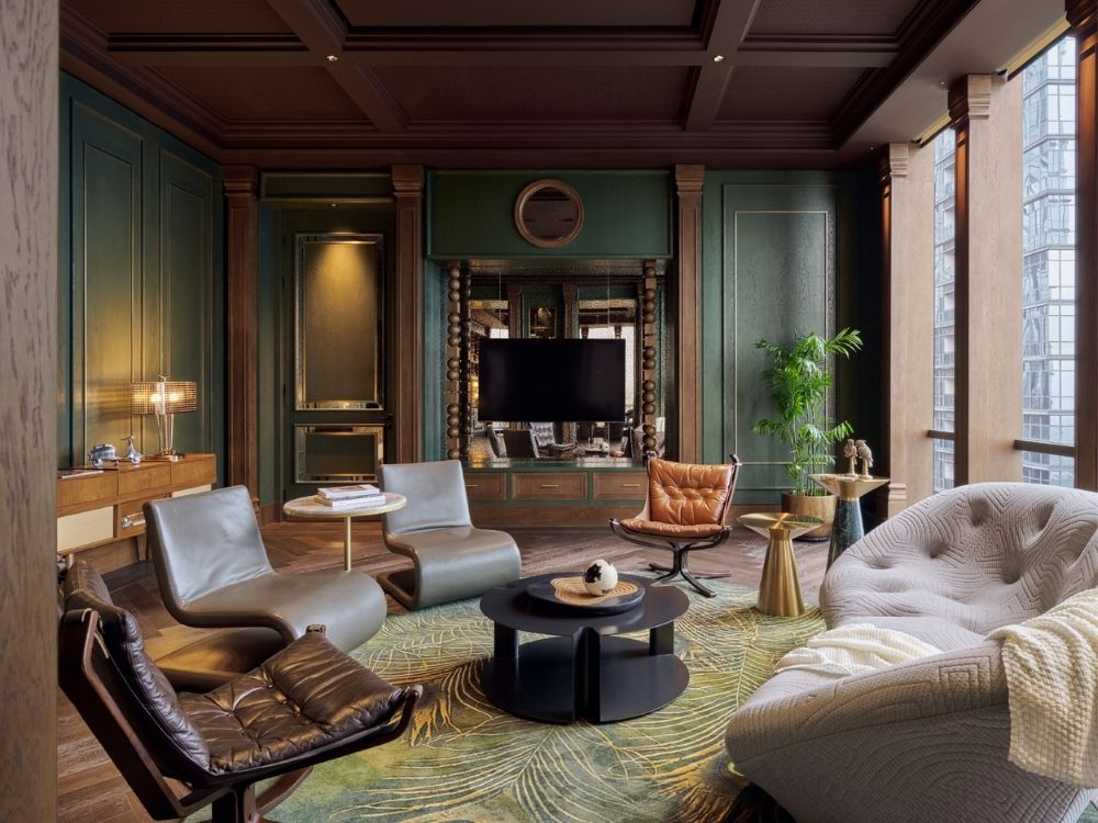 A stylish suite with green walls and a big TV, perfect for relaxation and entertainment.