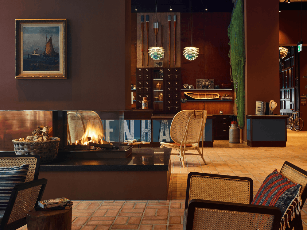 A cozy living room featuring a fireplace, two comfortable chairs, and warm lighting for a welcoming atmosphere.